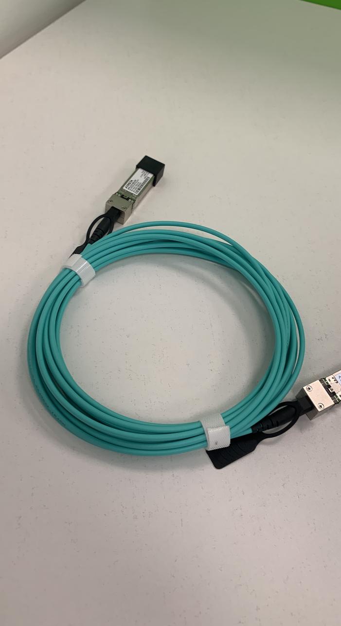 Single aqua active optical cable coiled on a white desk