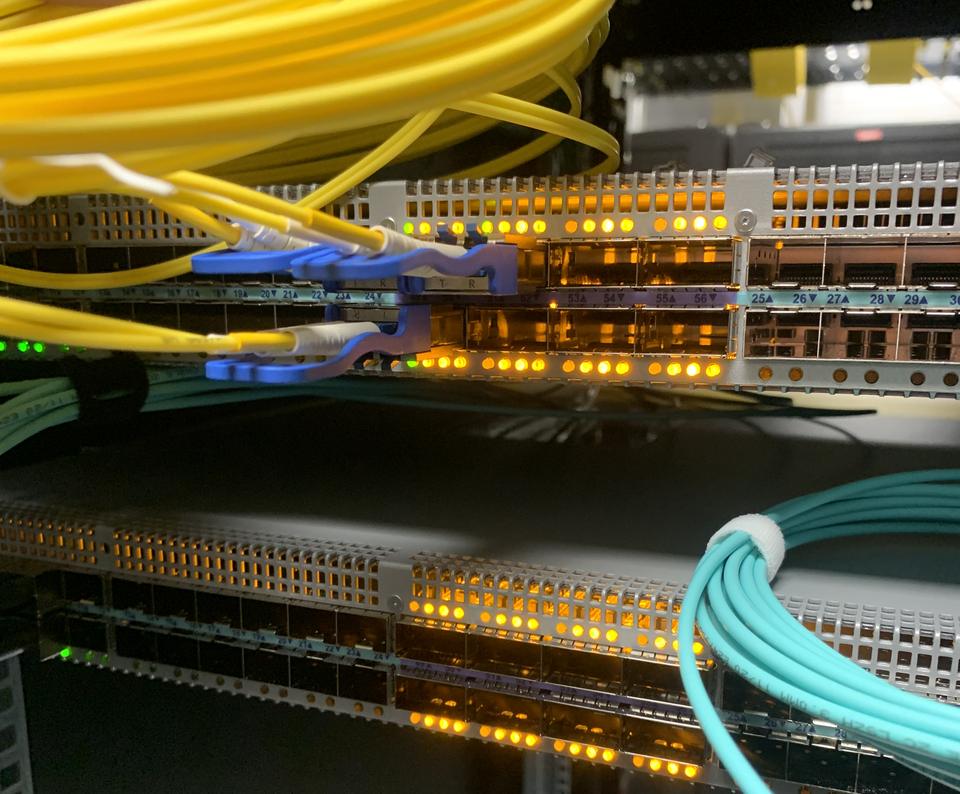 Yellow single-mode fibre patched into switch optics with amber port lights