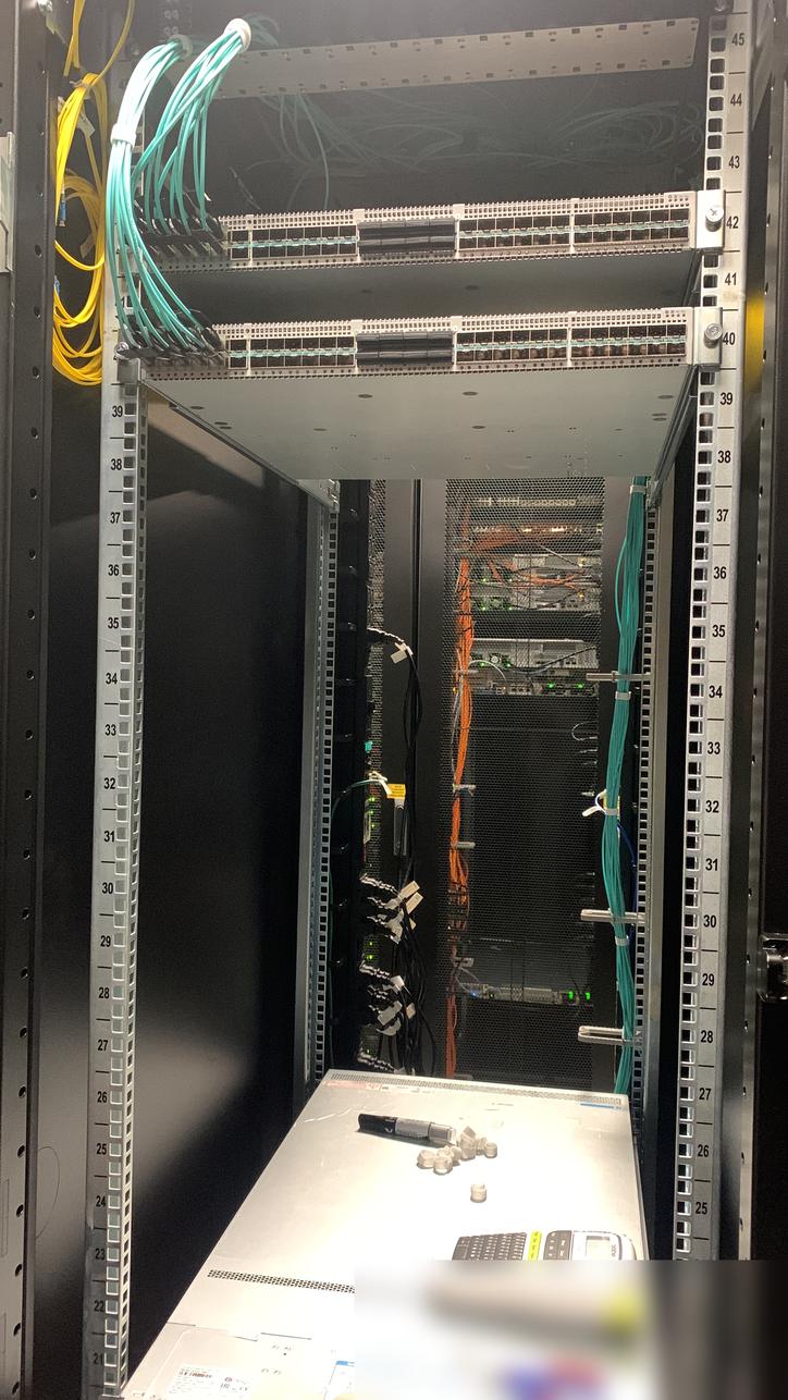 Open rack with two switches, fibre routed up the side and a label printer on a server below