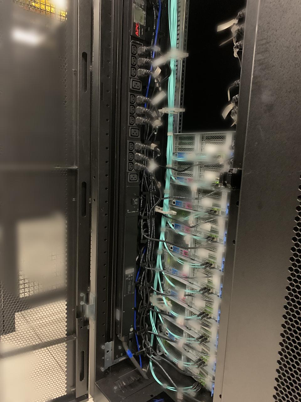 Open rack with servers and aqua fibre dressed down the side