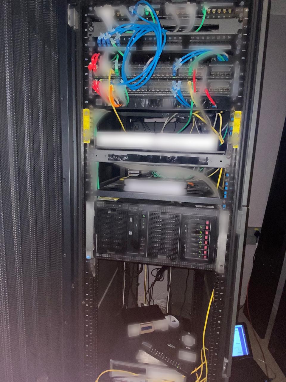 Comms rack with patch panels, colour-coded patch leads, switches and a server
