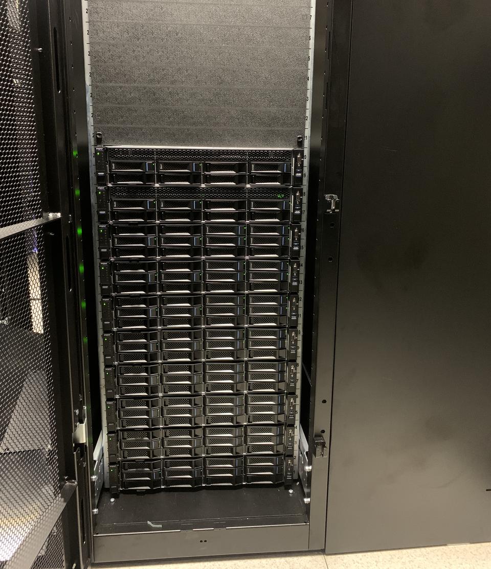 Cabinet door open on a rack full of high-density servers