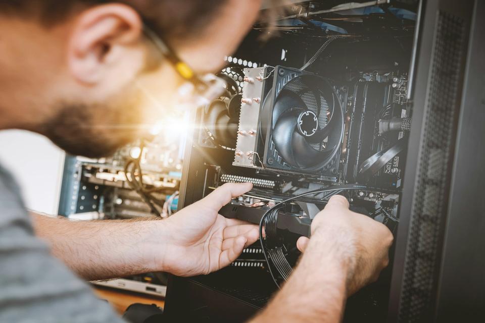 Engineer installing a component inside a computer