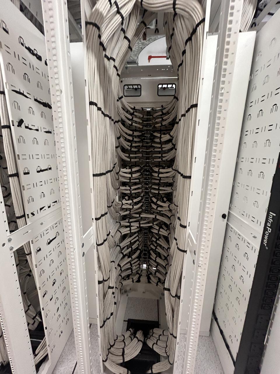 Patch leads routed through vertical cable managers in an open rack
