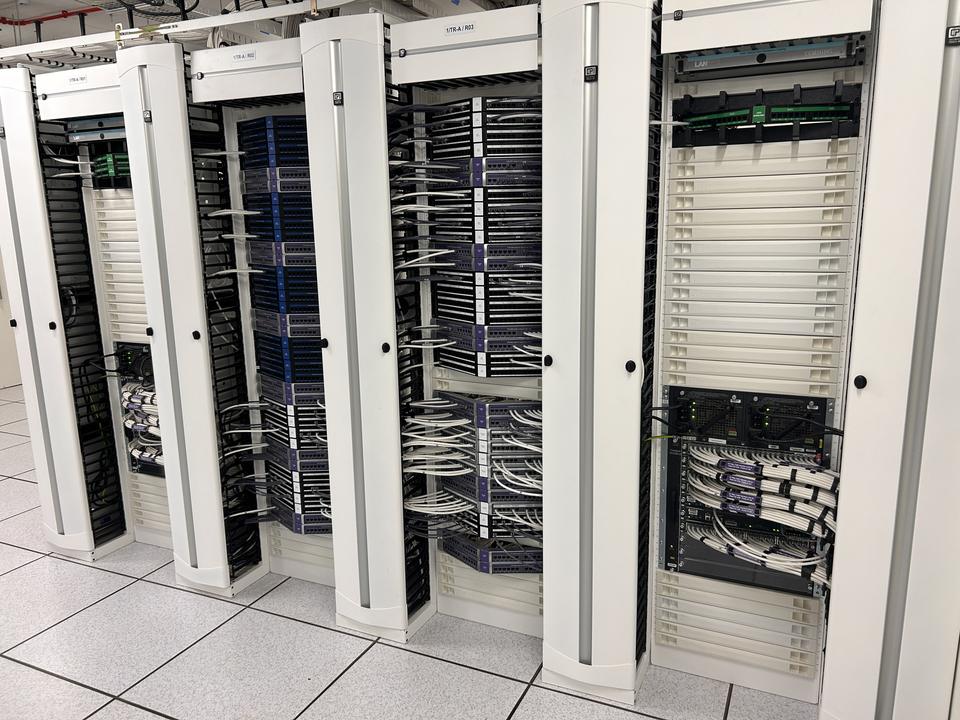 Row of open data centre racks, patched and cable-managed