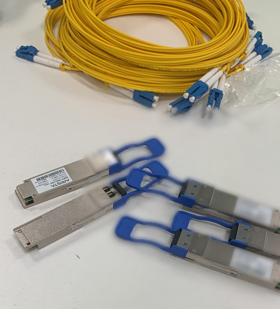 QSFP transceivers and yellow single-mode fibre patch leads on a desk